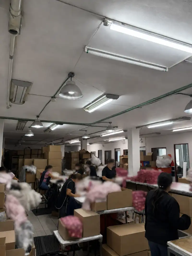 Área de trabajo en uso con mesas, mercancía y personas